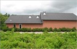 Bjøvlund Vandværk - Rød bygning med mørkt tag ved grusvej